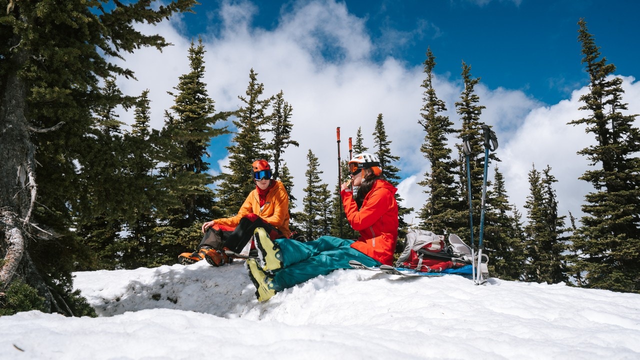 Nic (left) and Emma enjoy energy bars during their ski touring adventure.